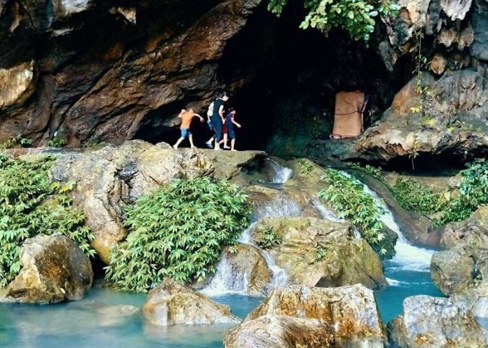 Khách du lịch trải nghiệm thăm quan suối và hang động mát mẻ